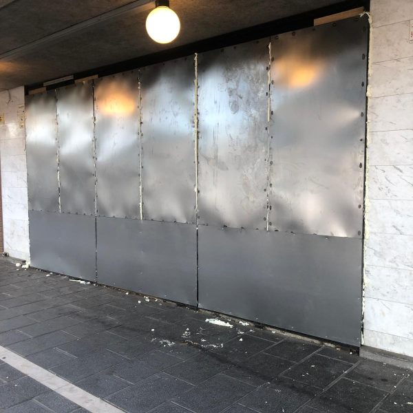 Puerta metálica de seguridad instalada en acceso a local comercial para prevenir ocupación ilegal